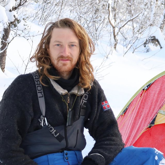 Portrait of Torstein Vabo Ansari, founder of Ericeira Tech Hub, at a winter camp in the Norwegian mountains beside an expedition tent.